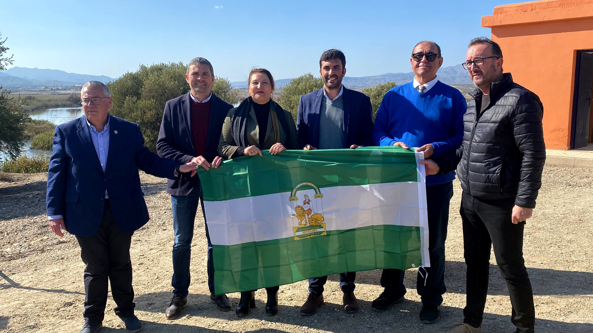 La consejera de Agricultura, Carmen Crespo, con el resto de los asistentes al acto portando la bandera de Andalucía.