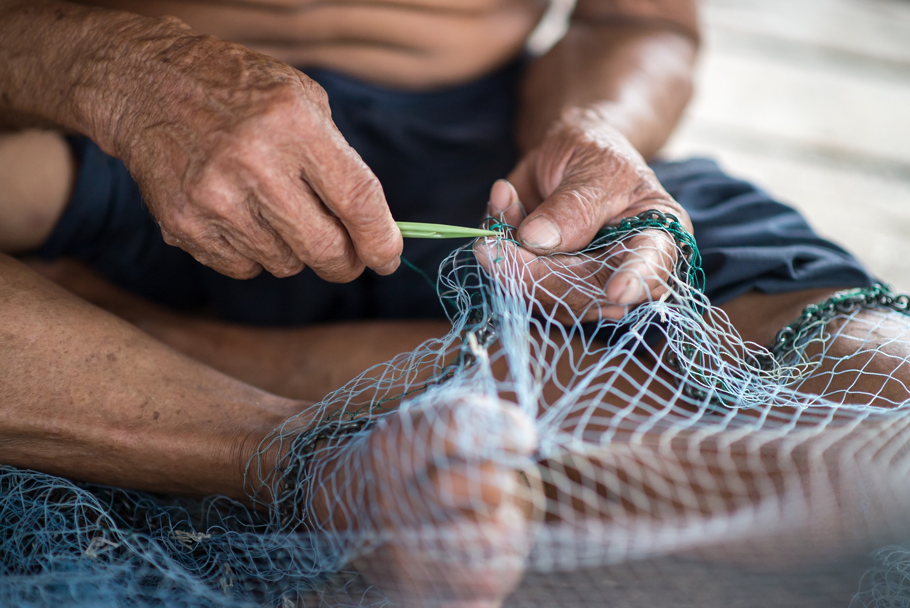Pescador reparando las redes que usan para la pesca.