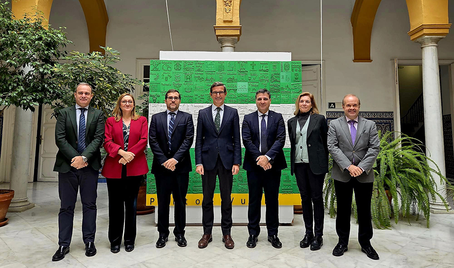 El consejero de Industria, Energía y Minas y presidente de la Agencia Digital de Andalucía, Jorge Paradela, posa junto al equipo directivo de la Consejería junto a la bandera en 3D elaborada en los Puntos Vuela de Andalucía para celebrar el 4 de diciembre.