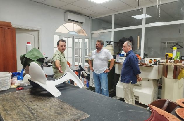 El joven empresario enseña a los representantes del IAJ y Empleo su negocio