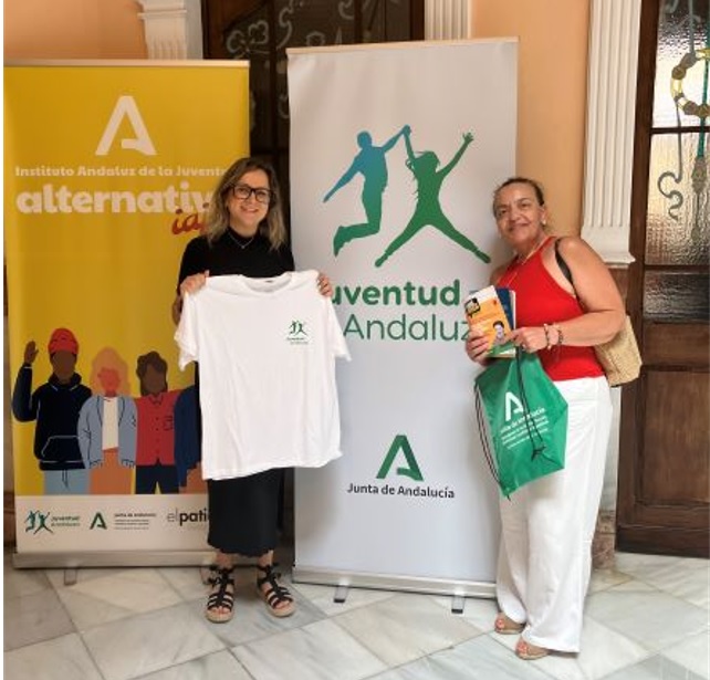 La responsable provincial del IAJ, a la izquierda, muestra una de las camisetas