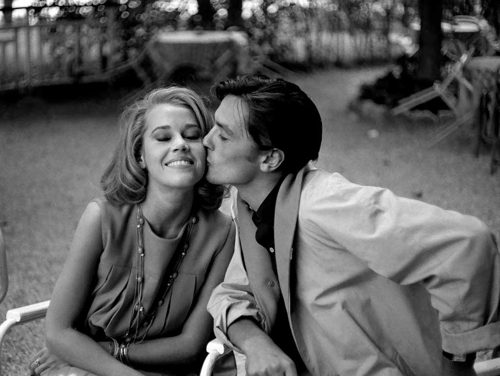El actor Alain Delon dándole un beso en la mejilla a la actriz Jane Fonda