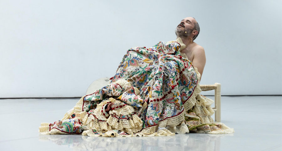 Actor sentado en el suelo cubierto con un traje de flamenca